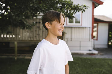 Lächelnder Junge schaut im Hinterhof weg - MASF21544