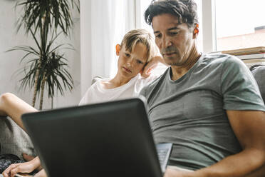 Father and son using laptop at home - MASF21604