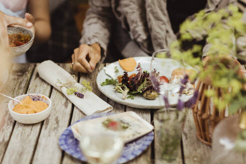 Mature woman sitting with food on table - MASF21634