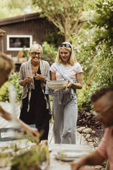 Family enjoying during garden party in back yard - MASF21636