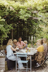 Glückliche Familie beim Essen auf einer Gartenparty - MASF21638