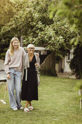 Grandmother and granddaughter spending leisure time in front yard - MASF21649