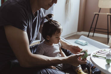 Midsection of father playing with male toddler in living room - MASF21675