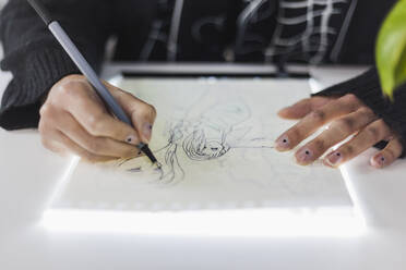 Weibliche Designerin beim Zeichnen auf Papier im Atelier - MGRF00158