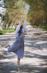 Fröhliche reife Frau tanzt im Park an einem sonnigen Tag - AZF00137