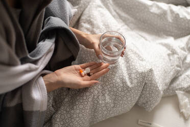 Crop ill woman taking pills in bed - CAVF92132