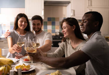 Diverse couple proposing toast to friends - CAVF92152