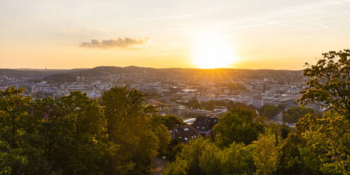 Germany, Baden-Wurttemberg, Stuttgart, Panorama of sun setting over city center seen from top of Uhlandshohe hill - WDF06528