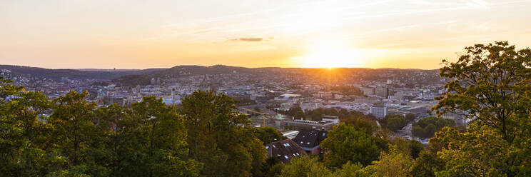 Germany, Baden-Wurttemberg, Stuttgart, Panorama of sun setting over city center seen from top of Uhlandshohe hill - WDF06529