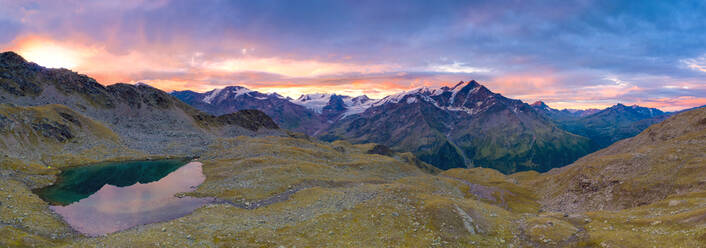 Pink sky at dawn on Forni Glacier and Tresero peak seen from lake Manzina, aerial view, Valfurva, Valtellina, Lombardy, Italy, Europe - RHPLF19068