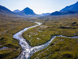 Aerial of a river snaking through the moor of the Black Cuillin ridge, Isle of Skye, Inner Hebrides, Scotland, United Kingdom, Europe - RHPLF19095