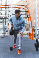 Sportler beim Training mit Sportgeräten auf einem Trainingsplatz in der Stadt - JAQF00247