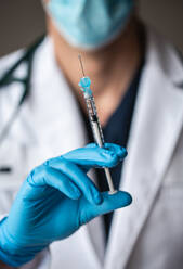 Close up of doctor holding needle with vaccine ready to inject. - CAVF92224