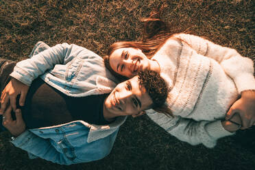 Aerial Shot Of A Smiling Couple Lying On The Grass - CAVF92242