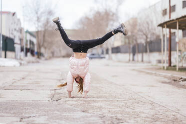 Mädchen macht Handstand auf der Straße gegen den Himmel - JCMF01886