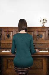 Woman playing piano at home - PSTF00824