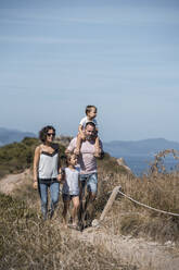 Familie beim Wandern auf einem Wanderweg vor blauem Himmel - SNF01160