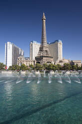 View across lake to replica Eiffel Tower at the Paris Hotel and Casino, Bellagio fountains in foreground, Las Vegas, Nevada, United States of America, North America - RHPLF19205