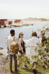 Glückliche Freunde spazieren am Meer am Hafen während der Sommerferien - MASF21794