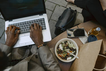 Hoher Blickwinkel auf die Hände eines Geschäftsmannes bei der Arbeit am Laptop - MASF21853