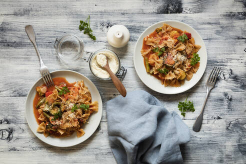 Zwei Teller Nudeln mit Fliege, Gemüse und veganem Parmesan - EVGF03893