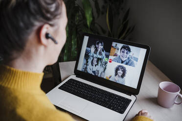 Young woman talking with friends over video conference on digital tablet while sitting at home - EBBF02454