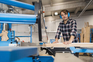 Arbeiter mit Gehörschutz bei der Arbeit in der Industrie - DIGF14401