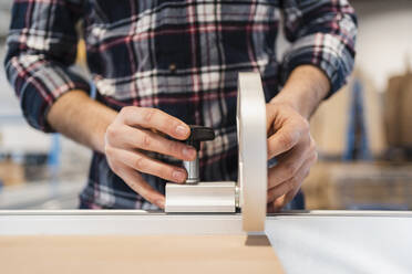 Manual worker working with hand tool while standing at industry - DIGF14405