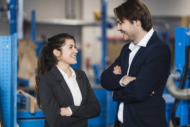 Young business people smiling while standing at industry - DIGF14491