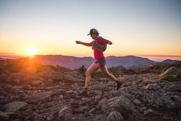 Woman running in the White Mountains at sunrise in summer - CAVF92317