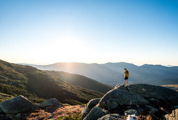 Mann blickt bei Sonnenaufgang über die Weißen Berge bei einem Trailrun - CAVF92323