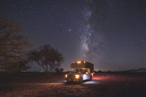 A small pickup RV is on a camping spot under the Milky Way - CAVF92350