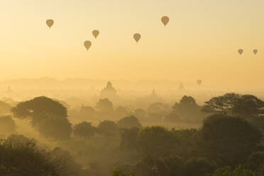 Antike Tempel und Heißluftballons bei nebligem Sonnenaufgang, Bagan, Ma - CAVF92395