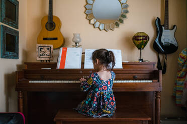 Mädchen spielt Klavier, niedliches Kind im Vorschulalter übt Musikinstrument - CAVF92397