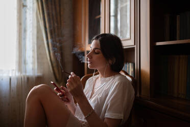 Young woman smoking and using smartphone - CAVF92410