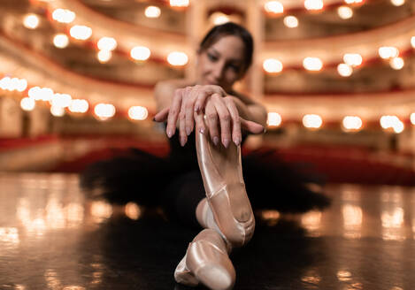 Ballerina stretching on stage before performance - CAVF92422