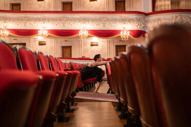 Female ballet dancer waiting for performance in auditorium - CAVF92436