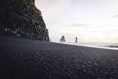 Detail des schwarzen Sandes am Strand von Reynisfjara in Island - CAVF92506