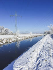 Klarer blauer Himmel über dem Fluss Nuthe im Winter mit Strommast im Hintergrund - ASCF01558