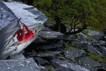 Frau beim Bouldern am Felsen im Schiefersteinbruch in Nordwales - CAVF92569