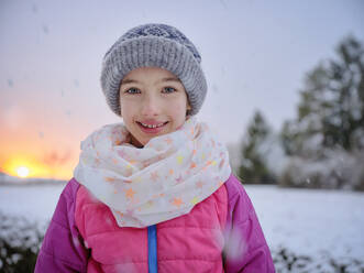 Cute smiling girl in warm clothing during sunset in winter - DIKF00559