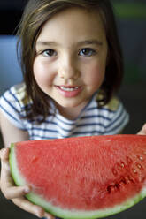 Lächelndes süßes Mädchen hält Wassermelone - IFRF00382