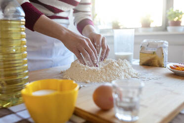 Frau bei der Herstellung eines Mehlhaufens in der Küche zu Hause - WPEF03989