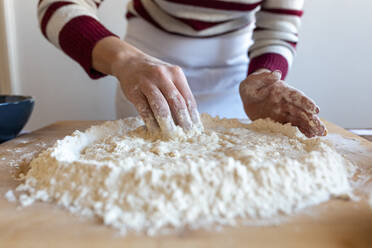 Woman making dough ready for preparation in kitchen - WPEF03995