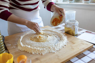 Woman mixing ingredient in dough while preparing criossants at home - WPEF03996