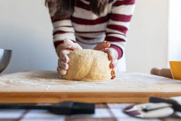 Frau formt Croissantteig auf einem Schneidebrett in der Küche - WPEF04001