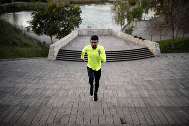 Male athlete running on steps at park - AMPF00004