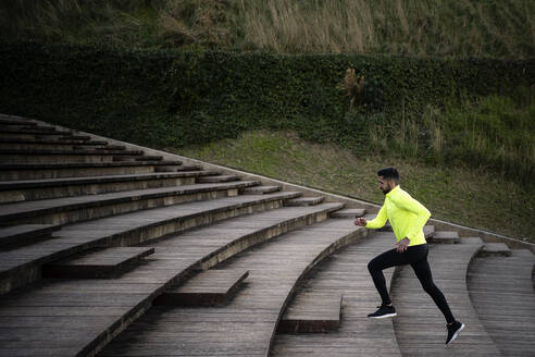 Male athlete running on steps at park - AMPF00016