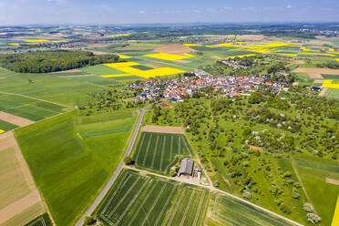 Deutschland, Hessen, Munzenberg, Blick aus dem Hubschrauber auf ein ländliches Dorf und die umliegenden Felder im Sommer - AMF09092