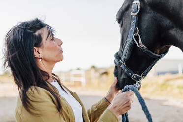 Mid adult woman looking at horse - MRRF00868